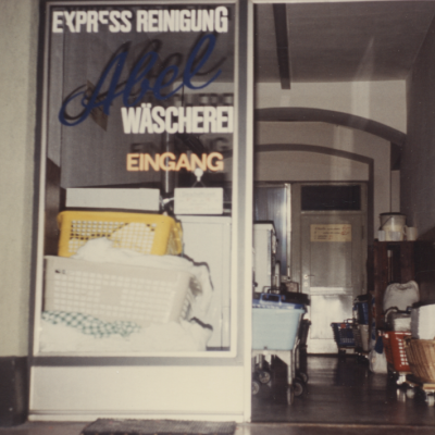 Ladeneingang der ersten Annahmestelle der Wäscherei in den 60er Jahren mit vielen bunten Wäschekörben.